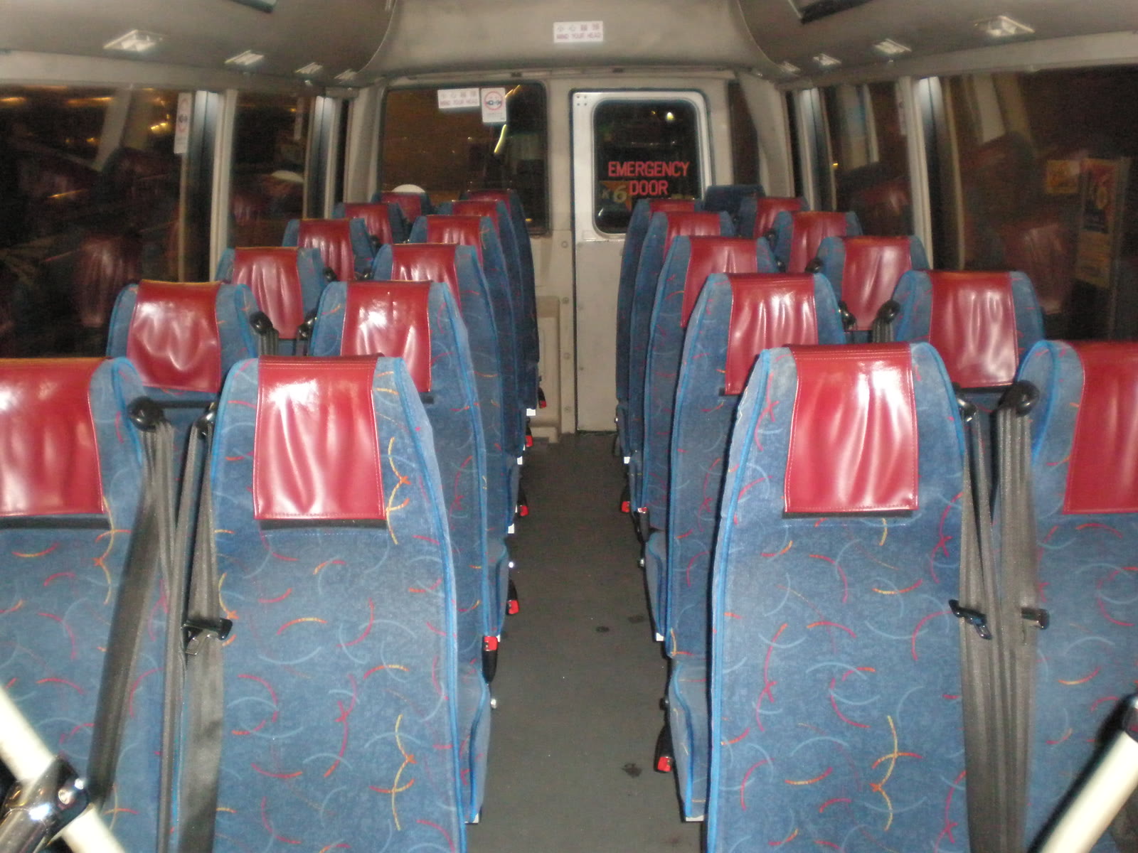 Bancos de um micro-ônibus, cada um com o seu cinto de segurança